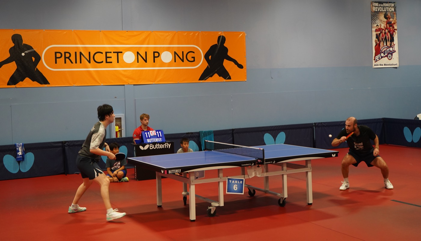 Two players rallying under the Princeton Pong banner, scoreboard at 11-11