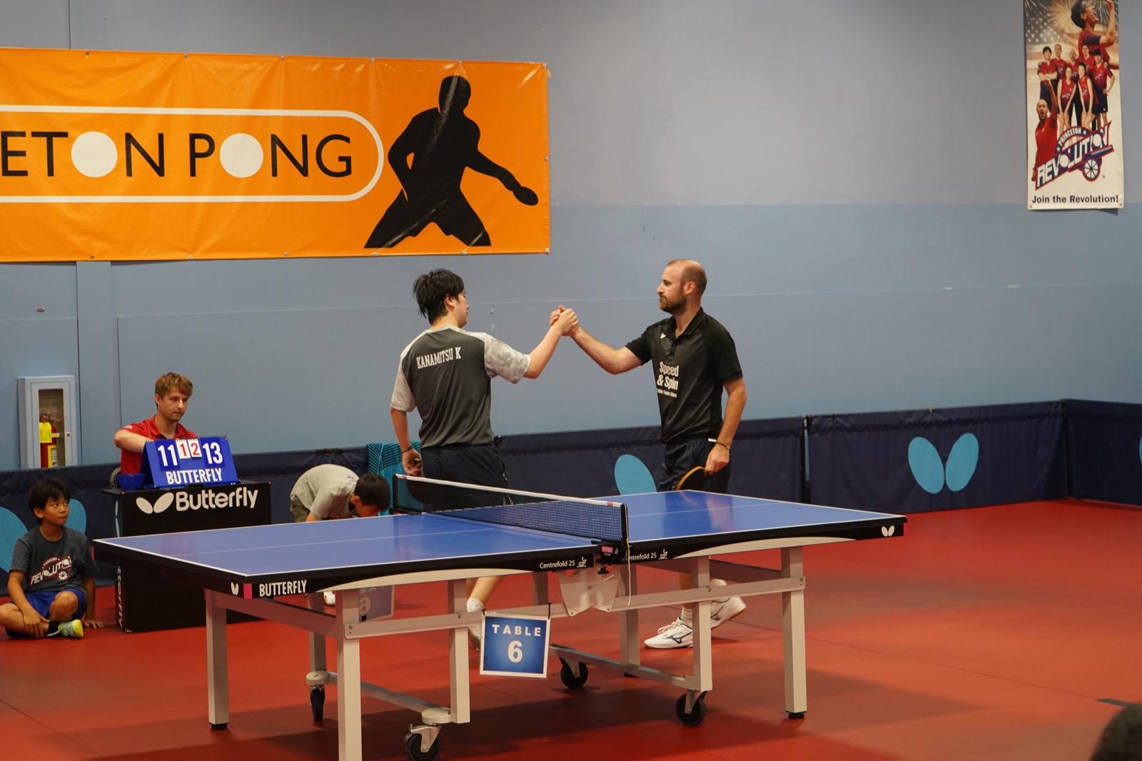 Two players shaking hands over the net after their match