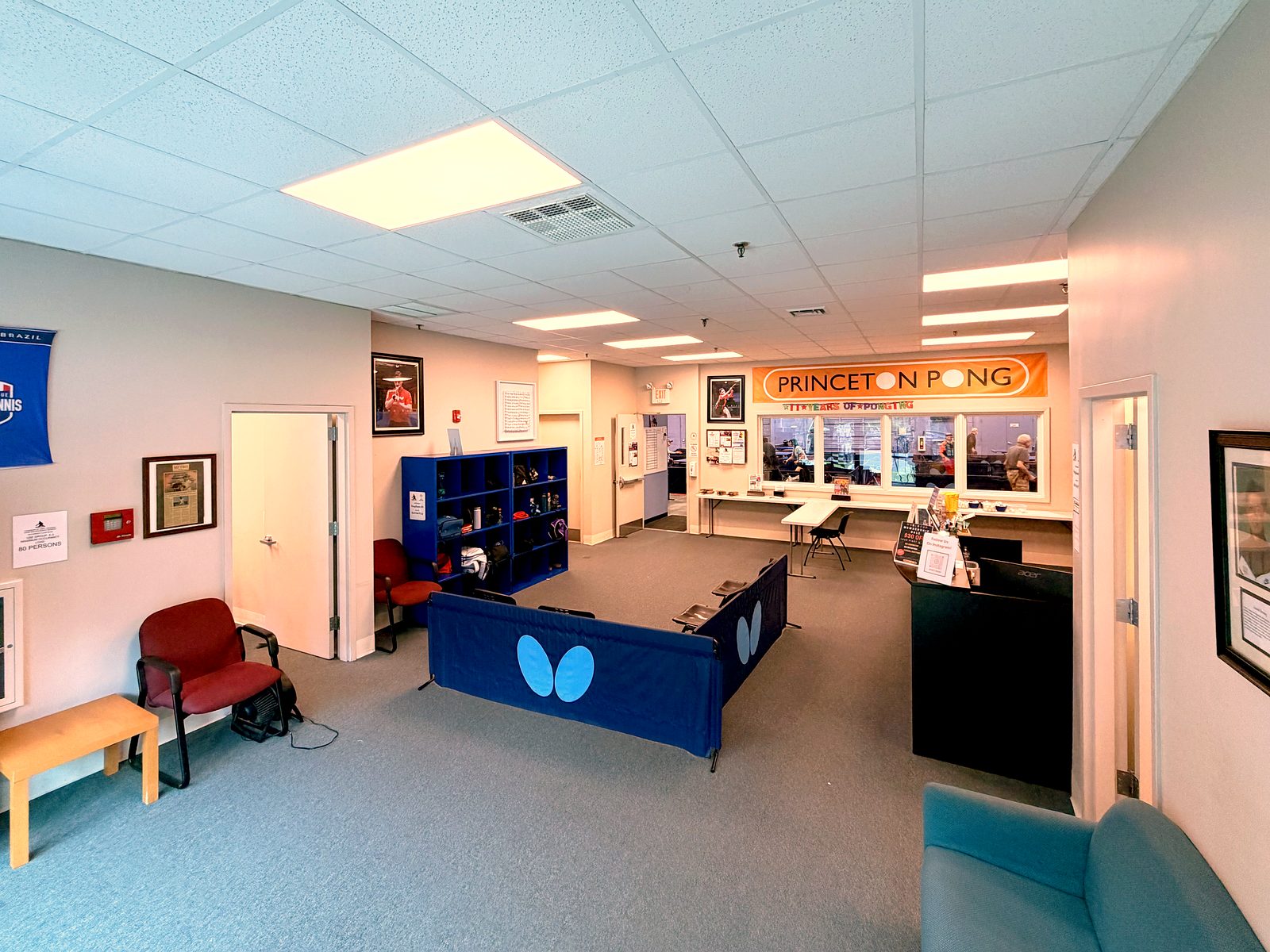 Front desk and lobby with the Princeton Pong banner and Butterfly barriers
