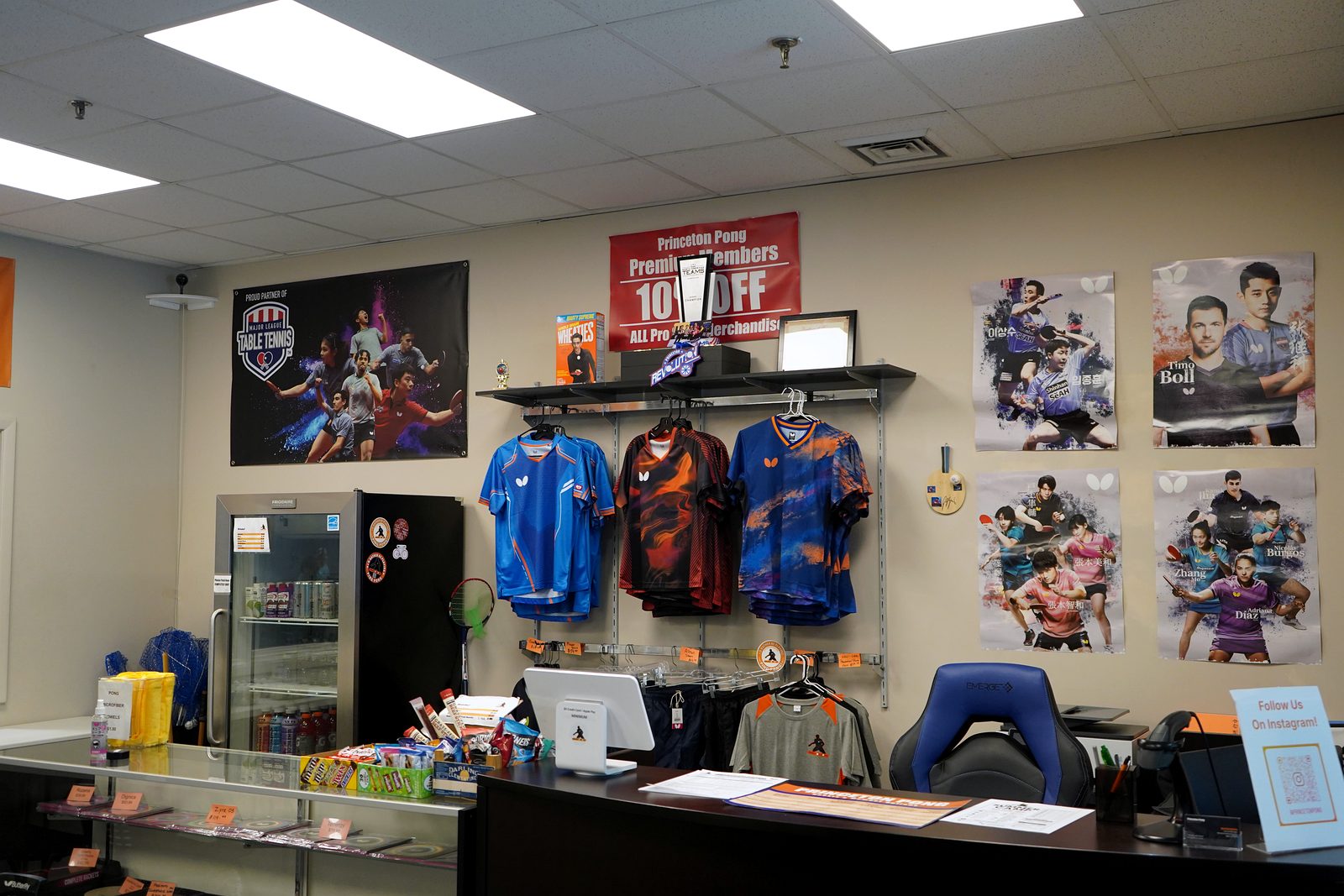 Pro shop counter with Butterfly jerseys, blades, and player posters
